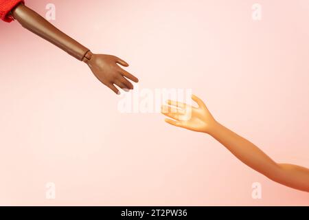 Two doll hands reach for each other on pink background. Different skin tones and races. Stop racism, diversity and unity, equality and feminism creati Stock Photo