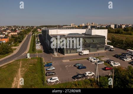 Drone photography of big logistical warehouse and its parking space in a city during autumn sunny day Stock Photo