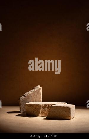 Stone podium, mock up for product cosmetic on dark beige background with dramatic light. Empty showcase for packaging presentation. Stock Photo