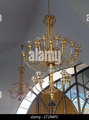 Bangkok, Thailand - Jul 28, 2023 - Chandelier (Chanderia) is hung on the roof, which is in the hall. The wall is decorated with ancient glass wall bac Stock Photo