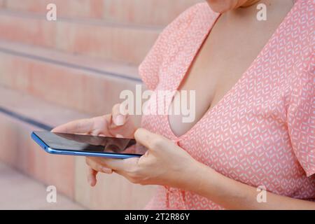 Close up beautiful young woman using mobile phone app outdoors. Stock Photo