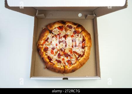 Tasty pepperoni pizza inside open box, on white background. Pizza in cardboard box Stock Photo