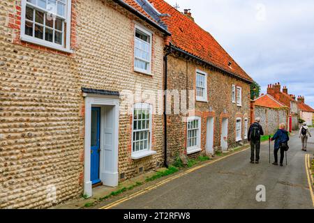 The 'vernacular' architecture of flints, bricks and pebbles is obvious in the High Street houses and cottages in Blakeney, Norfolk, England, UK Stock Photo