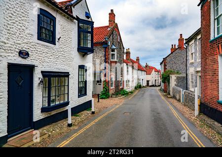 The 'vernacular' architecture of flints, bricks and pebbles is obvious in the High Street houses and cottages in Blakeney, Norfolk, England, UK Stock Photo