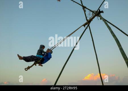 Kathmandu, Nepal. 20th Oct, 2023. A mother and her child enjoy traditional bamboo swing, especially made and played on the occasion of the 'Dashain' festival in Kathmandu, Nepal, on October 20, 2023. (Photo by Abhishek Maharjan/Sipa USA) Credit: Sipa USA/Alamy Live News Stock Photo