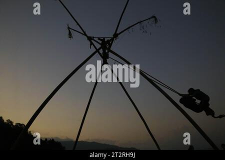 Kathmandu, Nepal. 20th Oct, 2023. Young girl enjoying traditional bamboo swing is silhouetted on the occasion of the 'Dashain' festival in Kathmandu, Nepal, on October 20, 2023. Traditional bamboo swings are especially made and played during the 'Dashain' festival in Nepal. (Photo by Abhishek Maharjan/Sipa USA) Credit: Sipa USA/Alamy Live News Stock Photo