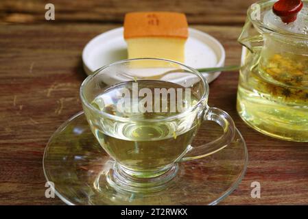 Cup of Hot Chrysanthemum Tea with Blurry Taiwanese Castella Cake in the Backdrop Stock Photo