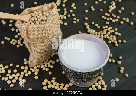 Cup of Soy Milk with a Burlap Bag of Soybeans on Wooden Table Stock Photo