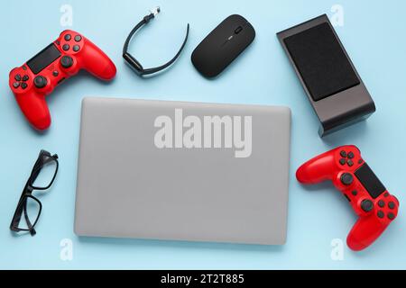 Modern gadgets with eyeglasses on blue background Stock Photo