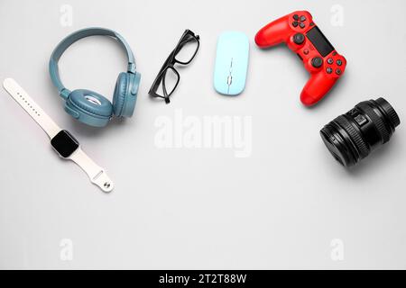 Frame made of modern gadgets with eyeglasses on light background Stock Photo