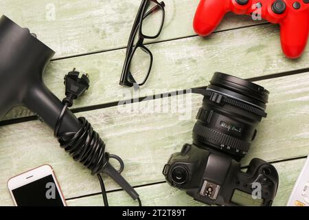 Modern gadgets with eyeglasses on green wooden background Stock Photo