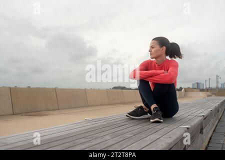 Sporty woman sitting resting after outdoor workout Stock Photo