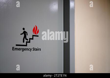 Signage pointing to emergency stairway on multi-level structure Stock Photo