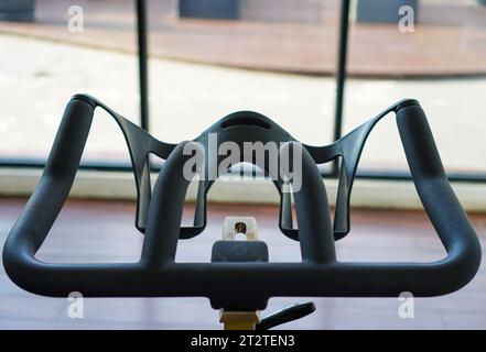 Close-up shot of static bike handlebars in gym. Detailed view of stationary bike handles in fitness room Stock Photo