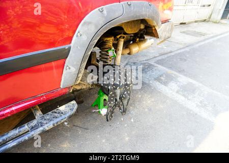 Car maintenance expert fixing wheel wrapped in cloth Stock Photo