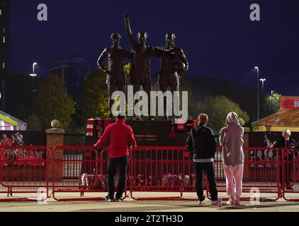 Tributes are laid in memory of Sir Bobby Charlton by The United Trinity statue at Old Trafford, Manchester. Sir Bobby Charlton has died aged 86, his family have announced. Issue date: Saturday October 21, 2023. Stock Photo