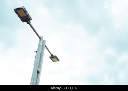 Stunning capture of LED street lights powered by solar technology against a backdrop of blue sky Stock Photo