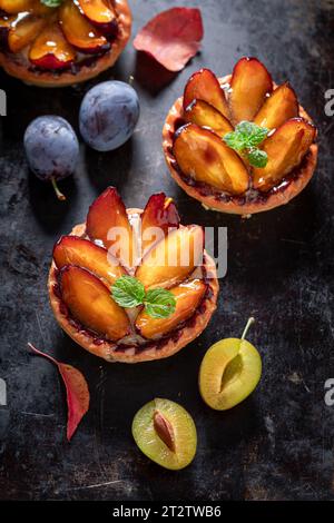 Delicious mini tart made of plums and cream. Cake with plums and cream. Stock Photo