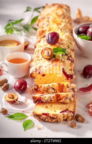 Plum yeast cake freshly baked in kitchen. Plum yeast cake with crumble and berries. Stock Photo
