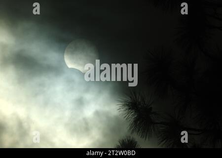 The sun is filtered by clouds in the waning phase of an annular solar eclipse on October 14, 2023. Stock Photo