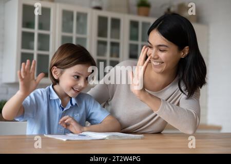 Happy Asian mother and son student giving high five Stock Photo