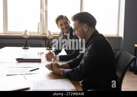 Two businessmen having fun, enjoying informal conversation at meeting Stock Photo