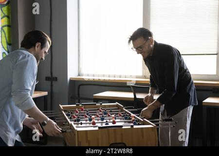 Two excited colleagues having fun at workplace during lunch break Stock Photo