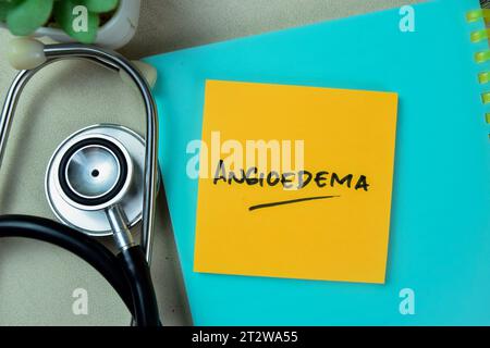 Concept of Angioedema write on sticky notes with stethoscope isolated on Wooden Table. Stock Photo