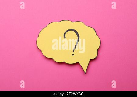 Paper speech bubble with question mark on pink background, top view Stock Photo