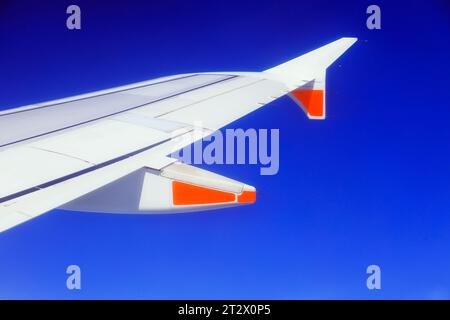 Fragment of airplane wing from window of passenger flight high in blue sky en route from Australia to New Zealand. Stock Photo