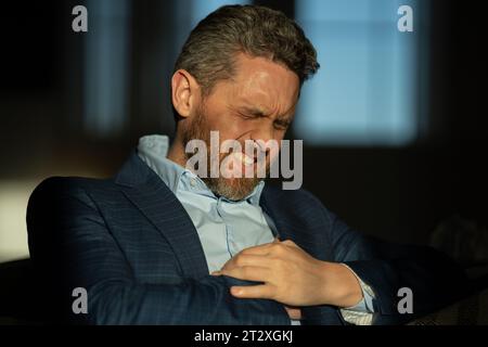 Stressed business man having headache at home office. Tired businessman is working overtime and has headache. Portrait of senior suffers from headache Stock Photo