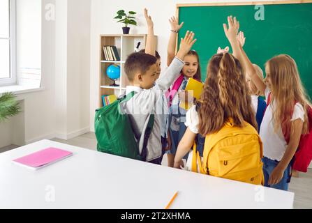 Elementary school students are having fun talking and raising their hands to vote. Stock Photo