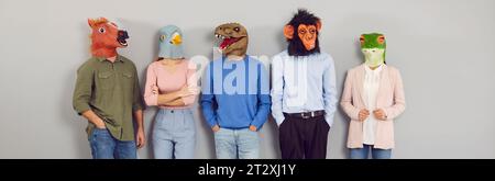 Creative young people communicate with each other wearing various masks in form of animal heads. Stock Photo