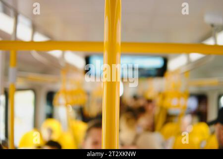 Blurred image of a yellow train with passengers in the background. Stock Photo