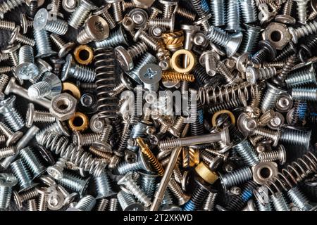Various fasteners, bolts, nuts, screws, springs piled up in a heap. Macro photography Stock Photo