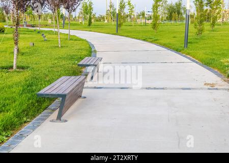 Background landscape with a path in the park in spring or summer with trees and a lawn for a walk Stock Photo