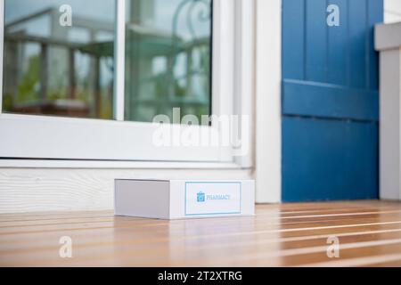 Medication package box Covid free first aid from pharmacy hospital delivery on floor at door front home patient Stock Photo