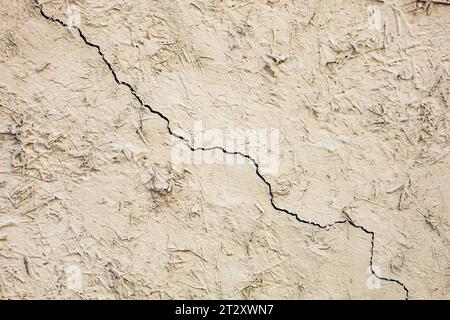Background texture cracked clay wall with old grunge coating on the surface. Stock Photo