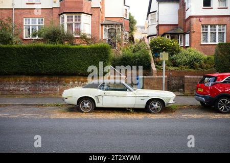Ford Mustang car dating from 1968 gradually falling into disrepair on a street in Scarborough Stock Photo