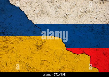 Demonstration of the conflict between Ukraine and Russia. Flag of the Kyiv regime and the Moscow regime on a cracked clay wall. Stock Photo