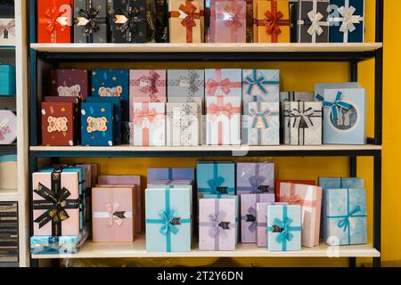 Colorful and patterned gift box stacks arranged on multi-tiered shelves Stock Photo