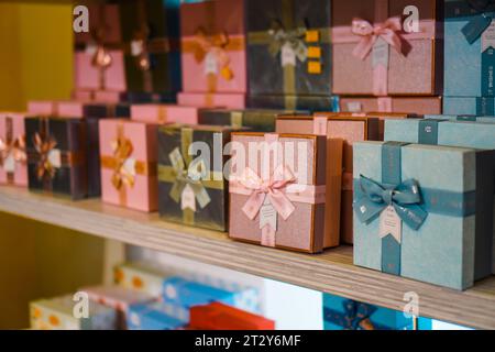 Colorful and patterned gift box stacks arranged on multi-tiered shelves Stock Photo
