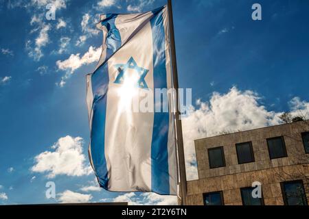 Israelische Fahne weht vor dem Jüdischen Gemeindezentrum am Jakobsplatz, München, Oktober 2023 Deutschland, München, Oktober 2023, Israelische Fahne weht vor dem Jüdischen Gemeindezentrum am Jakobsplatz, Sonne scheint durch die Israel Flagge vor blauem Himmel, Bayern *** Israeli flag flies in front of the Jewish Community Center at Jakobsplatz, Munich, Germany, October 2023, Israeli flag flies in front of the Jewish Community Center at Jakobsplatz, sun shines through Israel flag against blue sky, Bavaria Credit: Imago/Alamy Live News Stock Photo