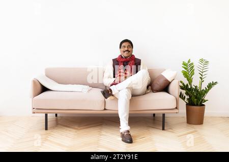 Happy mature hindu man in national costume chilling at home Stock Photo