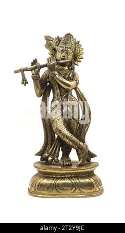 lord krishna playing flute music, an avatar of vishnu god of hindu religion, shiny bronze statue with a crown and ornamental details isolated Stock Photo