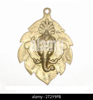 hindu god lord ganesha face antique sculpture on a leaf used as wall hanging display in gold isolated Stock Photo
