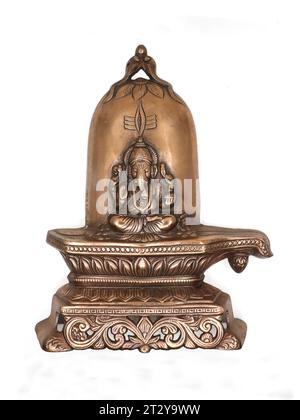 a bronze-copper statue of lord ganesh sitting on a sacred shiva linga stone decorated with pattern and carving isolated in a white background Stock Photo