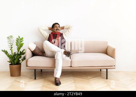 Smiling mature indian man in traditional clothes relaxing at home Stock Photo