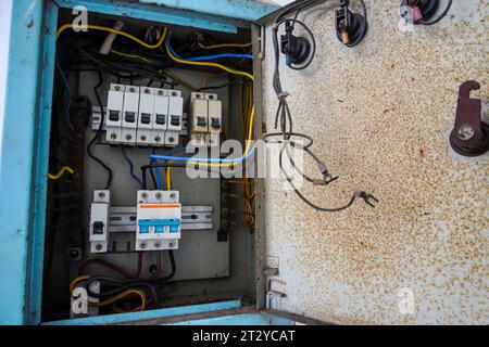 Power distribution board. Electrical panel with a row of fuses for different areas in a building, set against a white wall Stock Photo