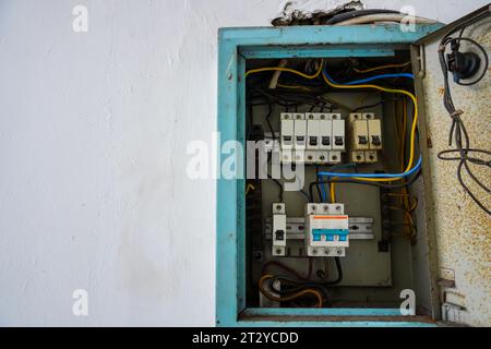 Circuit breaker panel. Electrical distribution for multiple rooms in a building, featuring a white wall background Stock Photo
